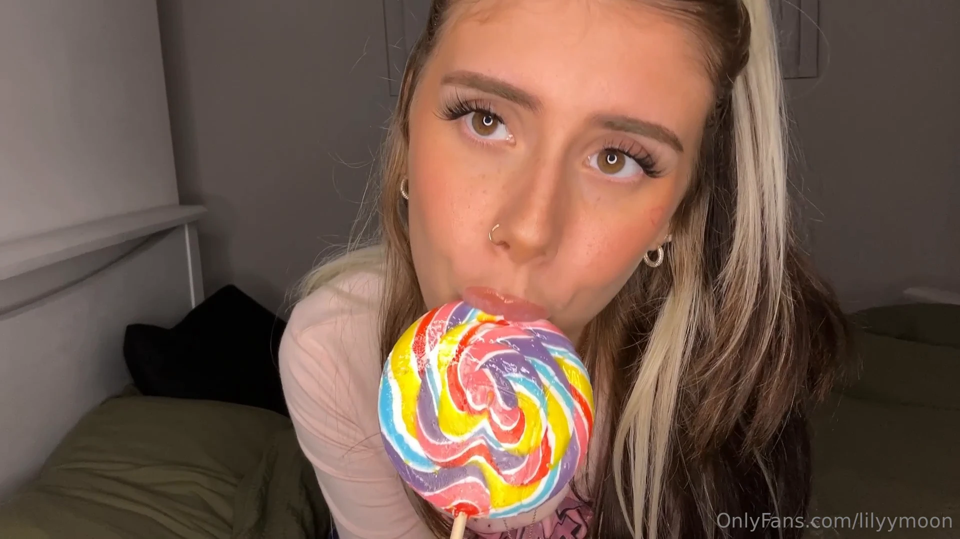 Lily Moon, all naughty and with a great body, holding her lollipop