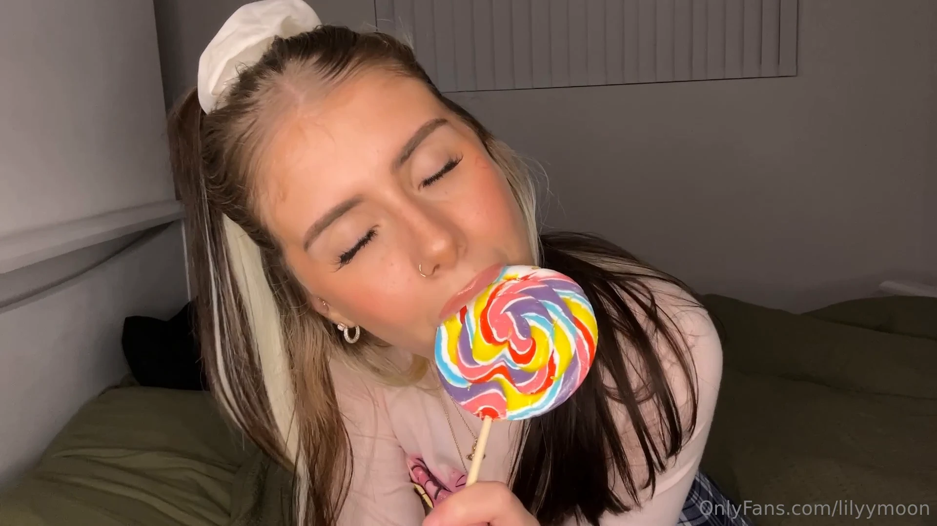 Lily Moon, all naughty and with a great body, holding her lollipop