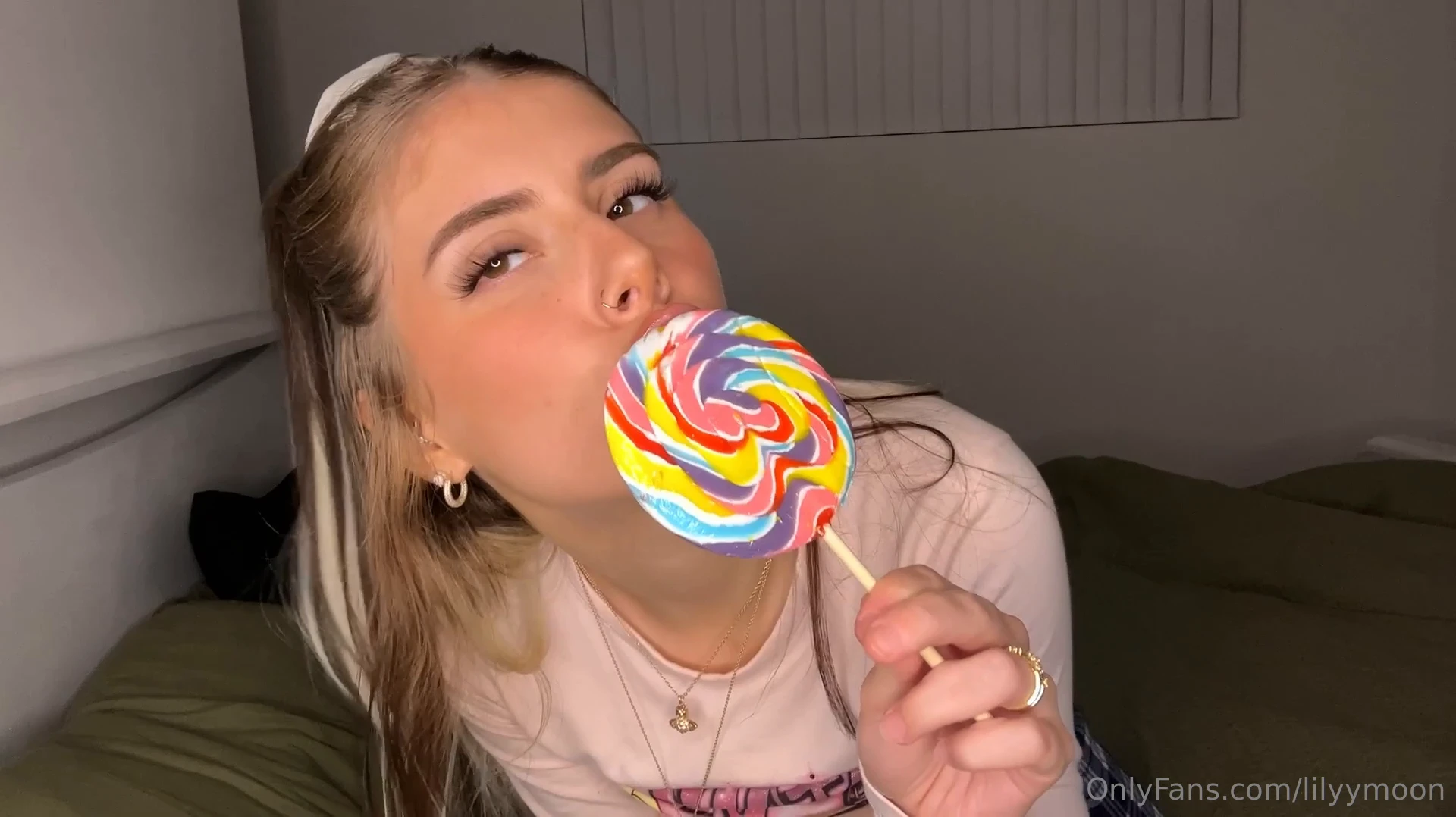 Lily Moon, all naughty and with a great body, holding her lollipop