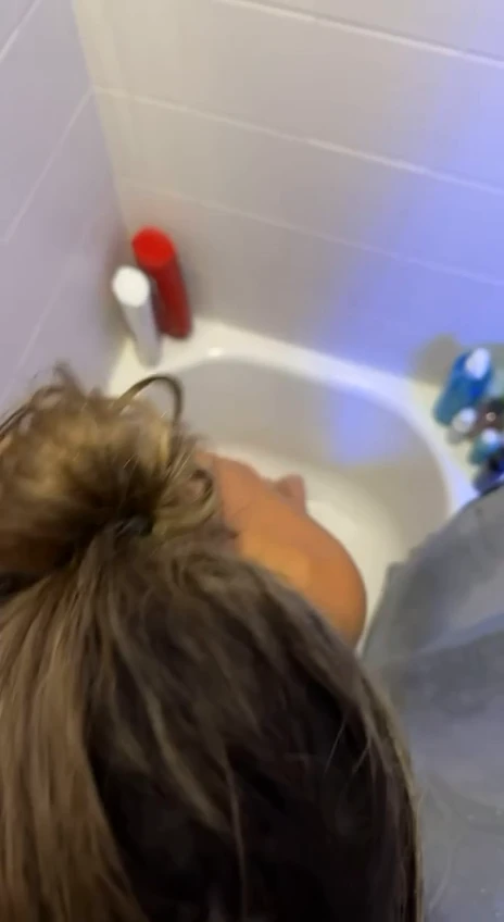 Ann Grayson, the cat, is taking a bite of the guy's toy